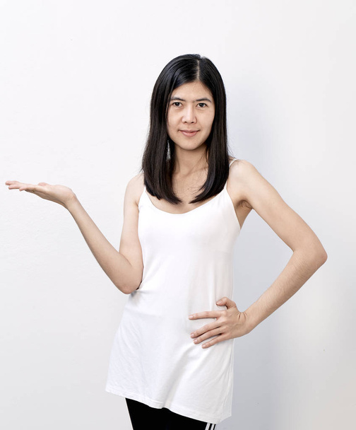 Sorridente snella donna asiatica che presenta copyspace sulle palme su uno sfondo bianco
 - Foto, immagini