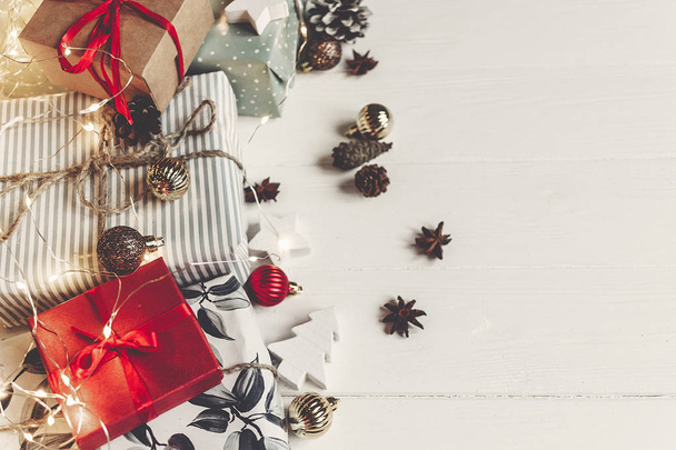 ライト上面、テキスト用のスペースと白い木製の背景に装飾品パイン コーン アニスと現在の箱をラップします。フラットのクリスマスが横たわっていた。季節のグリーティング カード。楽しい休暇をお過ごしください - 写真・画像