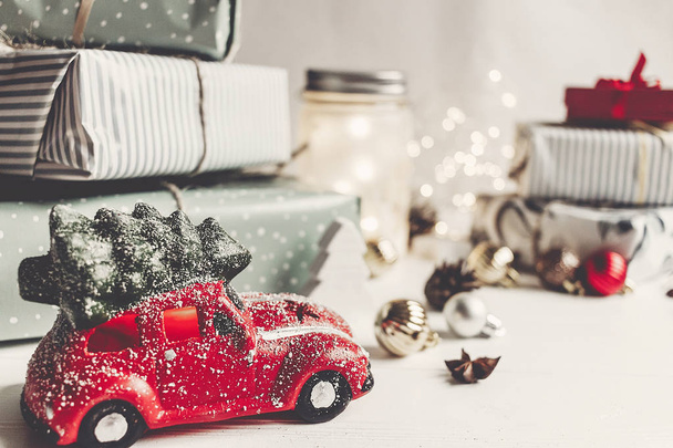 ornamenti natalizi moderni e giocattolo auto con albero, presenta coni di anice su sfondo bianco in legno. Buon Natale concetto. saluti stagionali. buone vacanze, cartolina di Natale, hygge
 - Foto, immagini