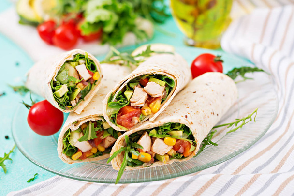 Burritos enveloppe avec du poulet et des légumes sur fond clair. Burrito au poulet, nourriture mexicaine
. - Photo, image