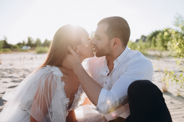 szép boldog pár csók a strand hátsó fény - Fotó, kép