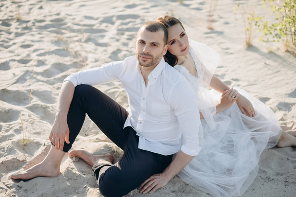 beautiful happy couple sitting on sandy beach - Fotoğraf, Görsel