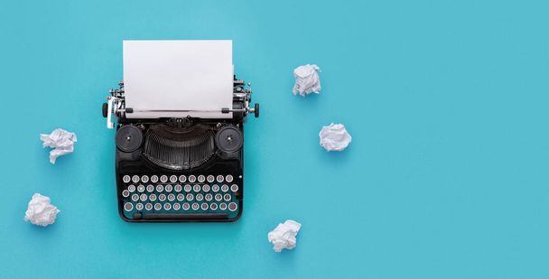 Винтажная пишущая машинка на синем фоне с копировальным пространством
 - Фото, изображение