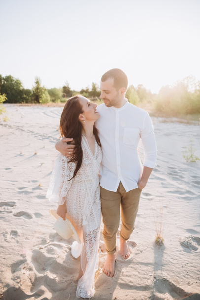 happy stylish couple hugging on beach with back light - Φωτογραφία, εικόνα