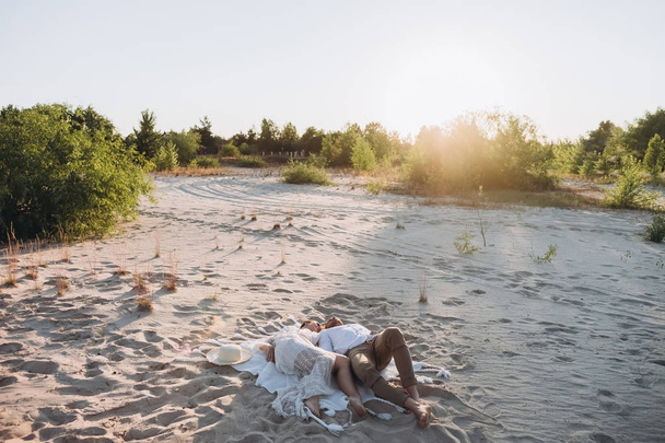 young couple lying on blanket on beach with sunlight - Fotoğraf, Görsel