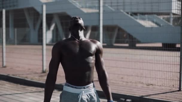 Seductive African American athlete restores his strength after a heavy workout outdoor. Motivation, pumping body, sports, gym, success, street workout, muscles. Shot on Red Epic - Footage, Video