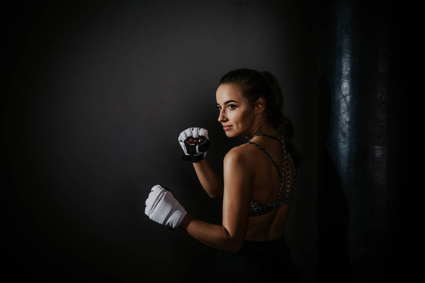 young beautiful girl boxer in a dark gym - Fotoğraf, Görsel