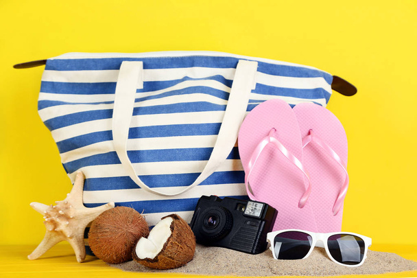 Summer accessories with retro camera and sunglasses on yellow background - Valokuva, kuva