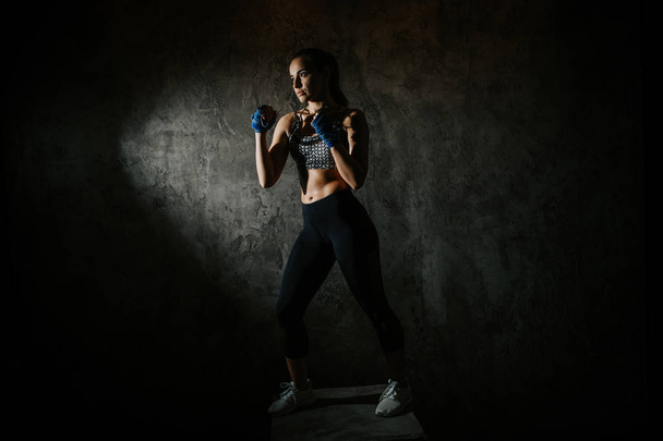молодая красивая девушка боксер в темном тренажерном зале
 - Фото, изображение