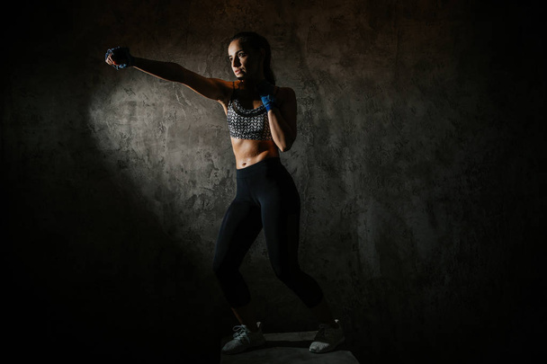 young beautiful girl boxer in a dark gym - Фото, зображення