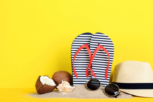 Flip flops with coconuts and seashells on yellow background - 写真・画像