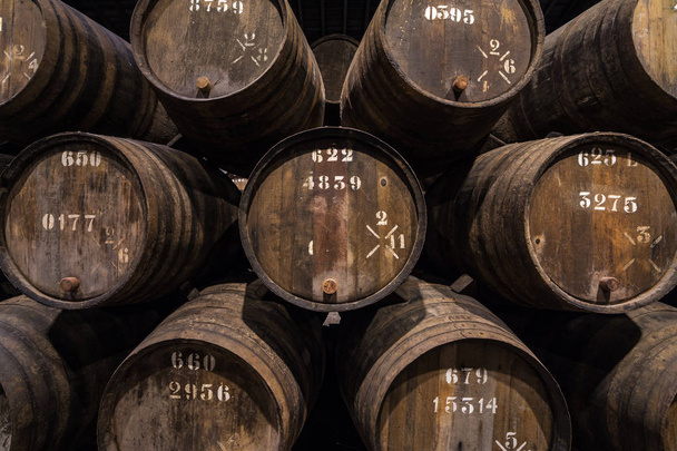 Row of wooden porto wine barrels in wine cellar Porto, Portugal. - Foto, imagen