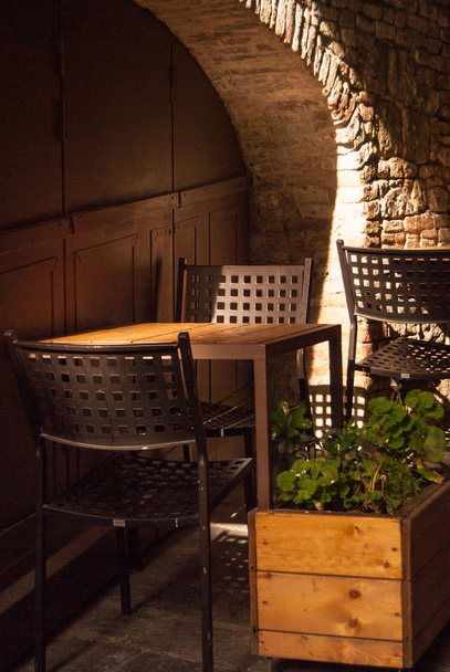Due sedie e un tavolo con geranio fuori da un ristorante italiano
 - Foto, immagini