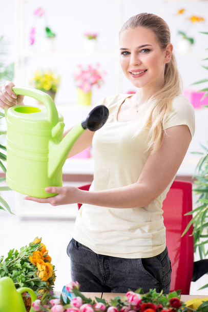 Young woman watering plants in her garden - Photo, image