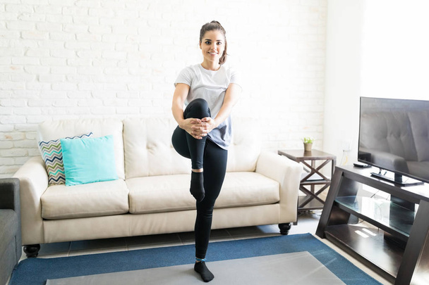 smiling woman doing warm up exercise in living room - Fotoğraf, Görsel