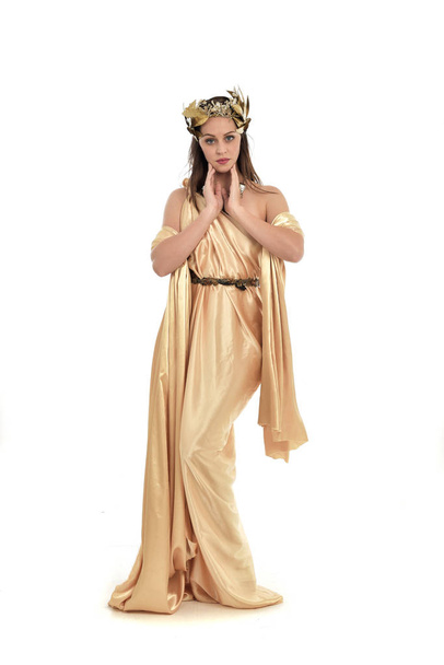 po celé délce portrét bruneta žena nosí zlaté Řecké šaty, stojící pozice. izolované na bílém studio pozadí. - Fotografie, Obrázek