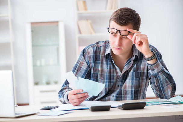 Jeune homme frustré par sa maison et les factures fiscales - Photo, image