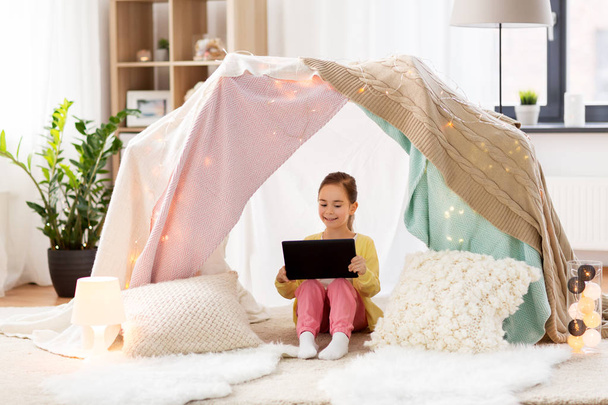 little girl with tablet pc in kids tent at home - Valokuva, kuva
