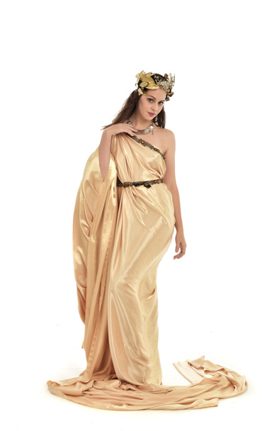 portrait complet de la femme brune portant une robe grecque en or, pose debout. isolé sur fond de studio blanc
. - Photo, image