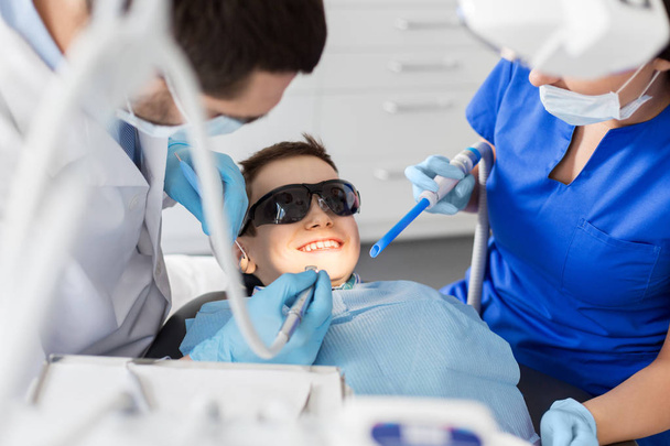 dentist treating kid teeth at dental clinic - Foto, imagen