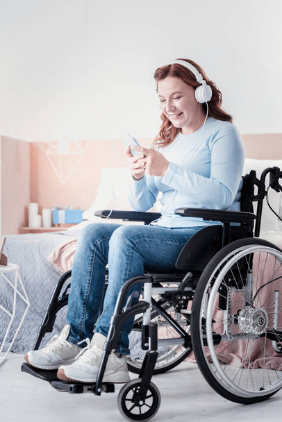 Glad handicapped woman listening to music - Photo, Image