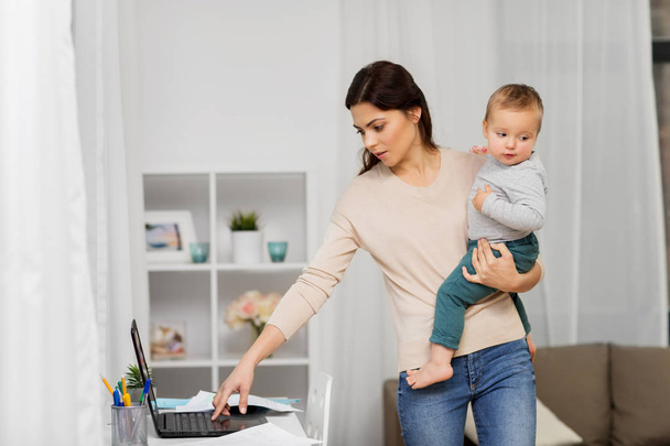 mother with baby and laptop working at home - Photo, image