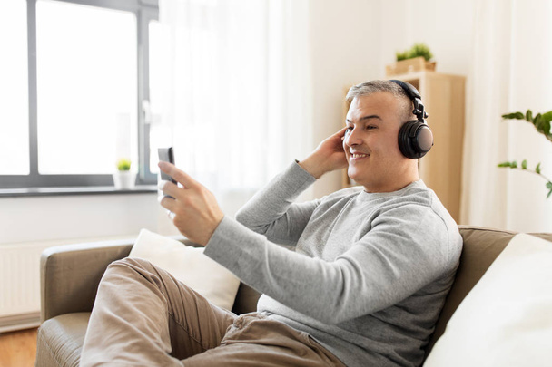 man with smartphone and headphones at home - Φωτογραφία, εικόνα