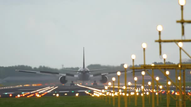 Samolot lądujący w oświetlony pas startowy - Materiał filmowy, wideo