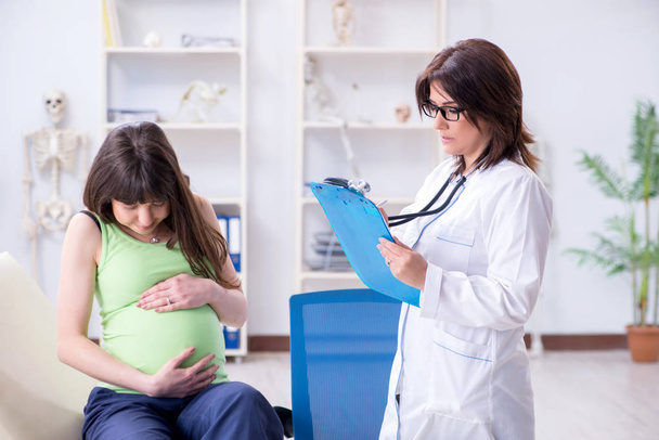 Pregnant woman visiting doctor for regular check-up - Фото, зображення