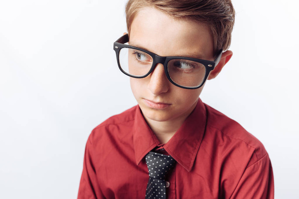Portrait of a positive and emotional teenager, white background, glasses, red shirt, business theme, - Fotoğraf, Görsel