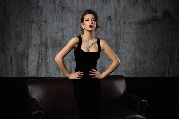 Gorgeous young brunette woman in elegant black dress posing - Foto, afbeelding