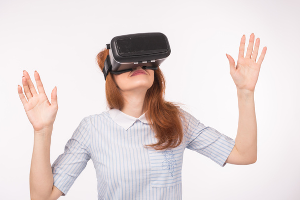 Heureuse jeune femme aux cheveux roux utilisant un casque de réalité virtuelle
 - Photo, image