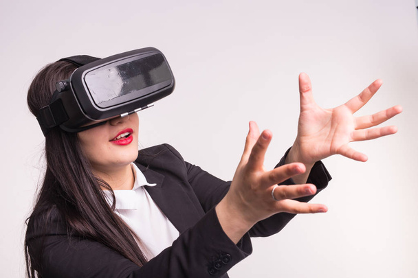Heureuse jeune femme excitée utilisant un casque de réalité virtuelle sur fond blanc
 - Photo, image