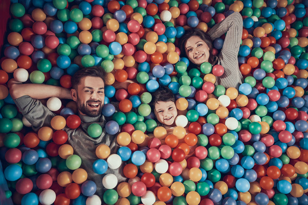 Top view. Happy family lying in pool with balls. Family rest, leisure concept. Spending holiday together. Entertainment center, mall, amusement park. - Foto, afbeelding