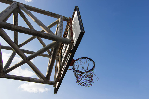 Old wooden basketball hoop with blue sky background  - Фото, изображение