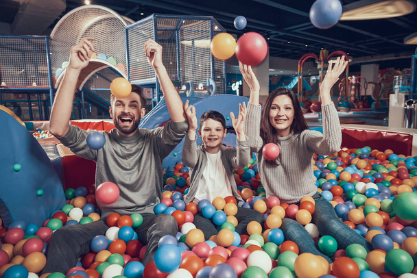 Happy family in pool with balls. Family rest, leisure concept. Spending holiday together. Entertainment center, mall, amusement park. - Photo, image