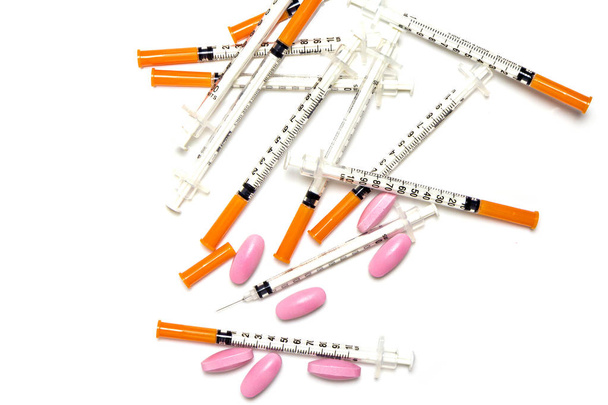 Medical syringe and pink pills isolated on white background - Photo, Image