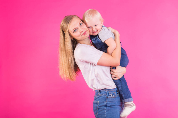Funny family on pink background. Mother and her daughter girl. Mom and child are having fun. - Photo, Image