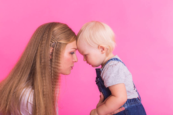 young mother and daughter having fun together on pink background - Photo, Image