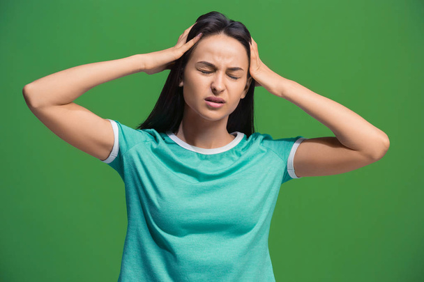 Woman having headache. Isolated over green background. - Foto, imagen