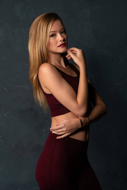 Tall slender blonde in a maroon top and slacks - Photo, Image