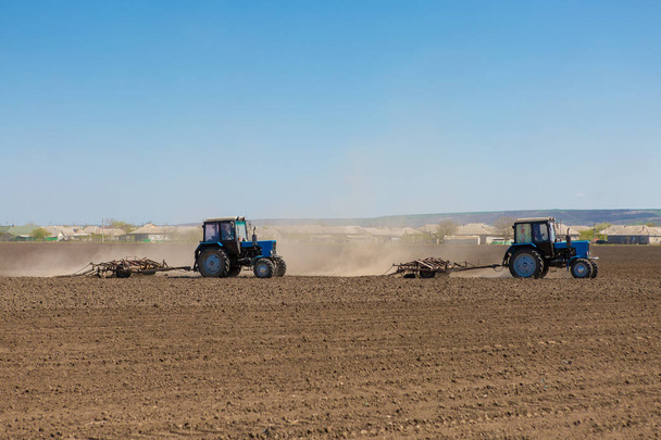 Трактори плугають поля навесні
 - Фото, зображення