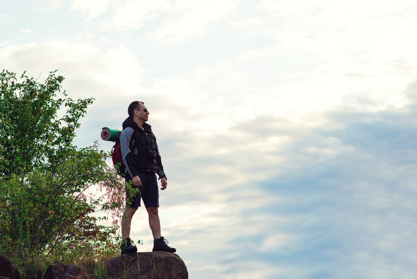 Hiker man with backpack standing on top of mountain - Fotó, kép