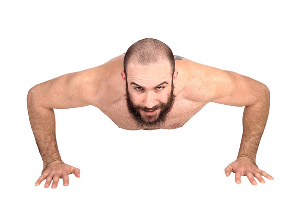 A young handsome man without a shirt doing push ups on the floo - Фото, изображение