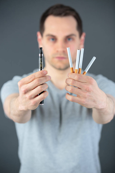 handsome man with e-cigarette and tobacco cigarette - Φωτογραφία, εικόνα