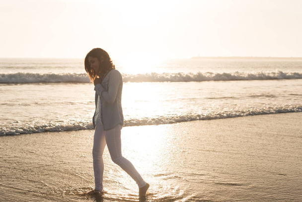 Красива жінка насолоджується заходом сонця на пляжі
 - Фото, зображення