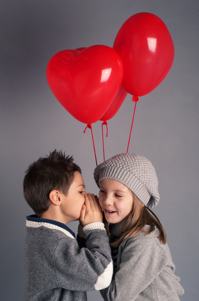 Young boy and girl with red heart balloons on grey background. V - Fotografie, Obrázek