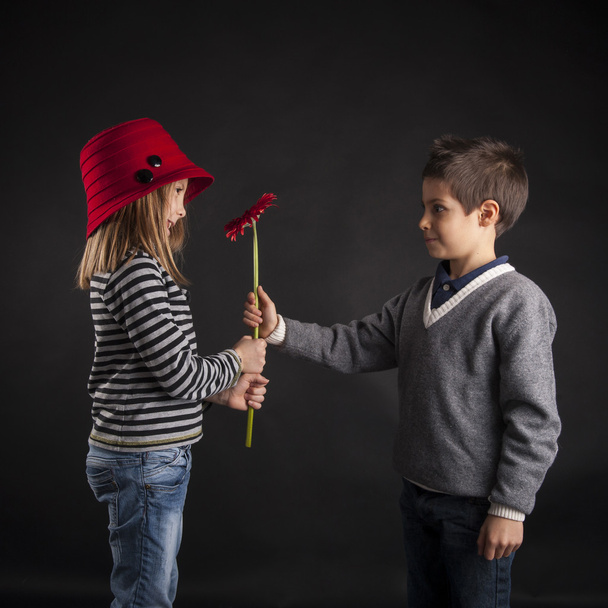 Boy offering flower on black background. Valentines day concept. - Fotografie, Obrázek