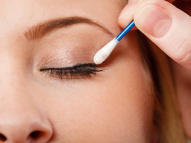 Visage, beauty concept. Closeup portrait of woman face getting her eye makeup done with cotton buds - Photo, Image