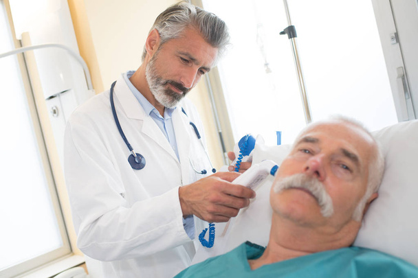 doctor examining a senior patient - Fotó, kép